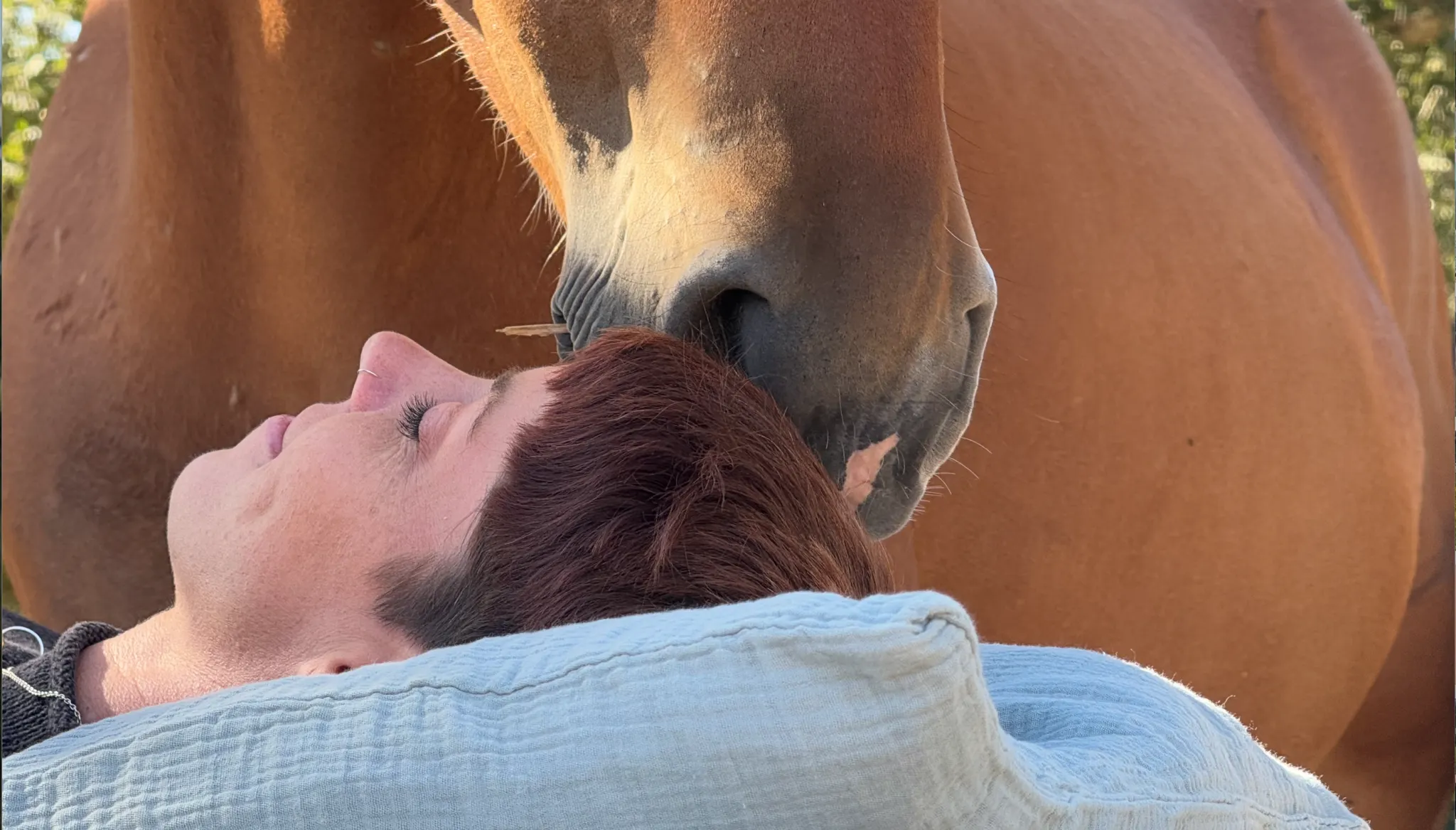 A woman resting her head against a horse